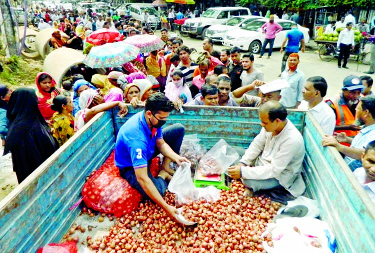 Huge customers crowd around a truck of Trading Corporation of Bangladesh (TCB) in front of Jatiya Press Club on Sunday to get two kilograms of onion each due to its exorbitant price at the markets across the country.