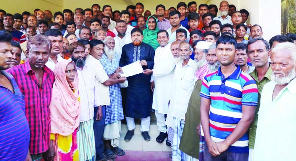 CHARGHAT(Rajshahi): Villagers of Padma Riverside at Charghat Upazila handing over a memorandum to Upazila Chairman and Awami League Secretary Faqrul Islam to stop illegal sand lifting recently.