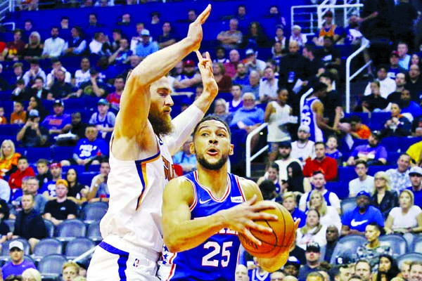 Philadelphia 76ers guard Ben Simmons (25) drives to the basket against Phoenix Suns center Aron Baynes ( left) during the first half of an NBA basketball game in Phoenix on Monday