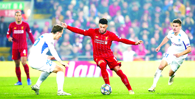 Liverpool's Alex Oxlade-Chamberlain (center) in action with KRC Genk's Sander Berge at Anfield in Liverpool on Tuesday.