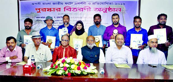 Housing and Public Works Minister SM Rejaul Karim poses for a photo session along with award recipients of Rupashi Bangla National Photo Exhibition and Competition organised by Bangladesh Photo Journalists Association at the Jatiya Press Club on Thursday.