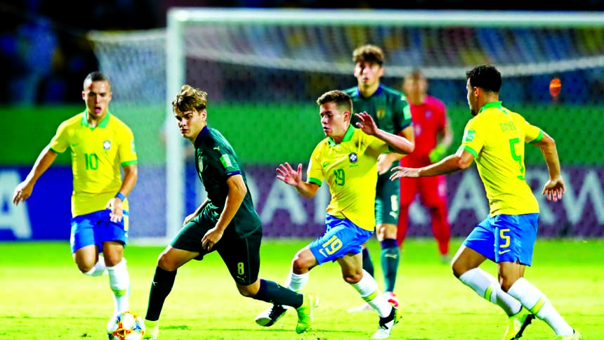 Michael Brentan (front) of Italy looks to break past Pedro Lucas (center) of Brazil and Daniel Cabral (right) of Brazil during the FIFA U-17 World Cup quarter-final match between Italy and Brazil at the Olympic Stadium Goiania in Goiania, Brazil on Monday