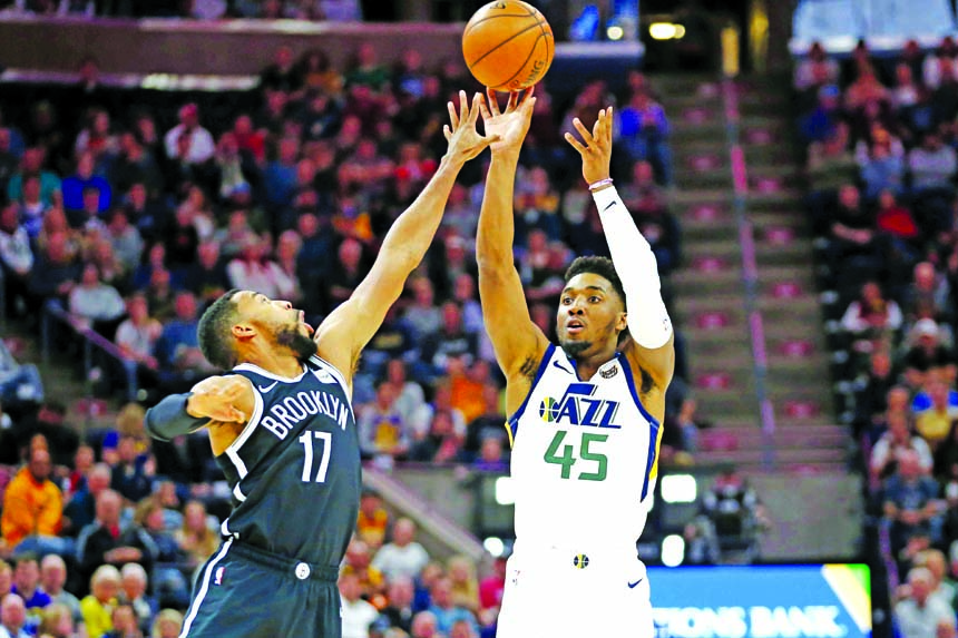 Utah Jazz guard Donovan Mitchell (45) shoots as Brooklyn Nets guard Garrett Temple (17) defends in the first half during an NBA basketball game in Salt Lake City on Tuesday.