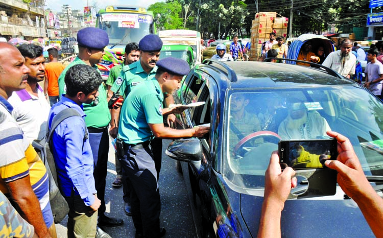 Officials of Lalbagh Traffic Zone distributing leaflets among the drivers and transport workers at Nayabazar in Dhaka on Wednesday as part of its public awareness campaign on the new Road Transport Act.