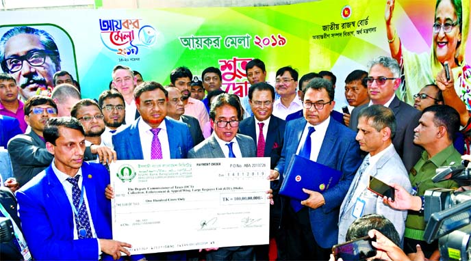 Muhammad Qaisar Ali, Managing Director (Current Charge) of Islami Bank Bangladesh Limited, handing over a cheque of Tk 100 crore as Income Tax to Finance Minister A H M Mustafa Kamal at Income Tax Fair at the Officers Club in the city on Thursday. Md Mosh