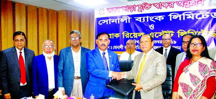 Md Ataur Rahman Prodhan, Managing Director of Sonali Bank Limited and Mohammad Noor Ali, Chairman of Unique Group and Managing Director of Borak Real Estate Limited, exchanging documents after signing an agreement at the bank's head office c on Thursday.