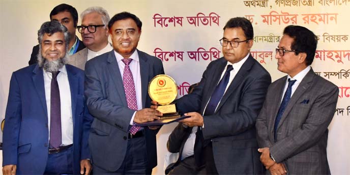 Finance Minister A H M Mustafa Kamal, handing over the Crest & Tax Card to Muhammad Qaisar Ali, AMD of Islami Bank Bangladesh Limited, at the Hotel Radisson Blu in the city recently. Dr. Mashiur Rahman, Economic Affairs Adviser to the Prime Minister, Md.