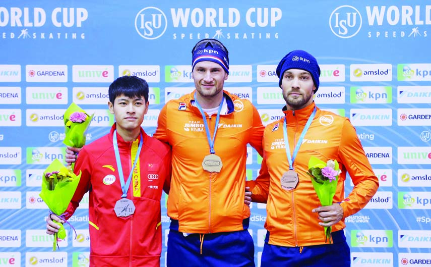The Netherlands' Thomas Krol (center) winner of the men's 1000 meters race celebrates on the podium with second placed China's Zhongyan Ning (left) and the Netherlands' Kjeld Nuis during the speed skating World Cup at the Minsk ice arena in Minsk,