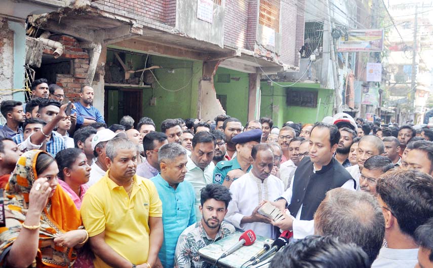 Deputy Education Minister Mohibul Hasan Chowdhury Nowfel MP distributing money yesterday among the family members of gas line explosion at Patharghata.