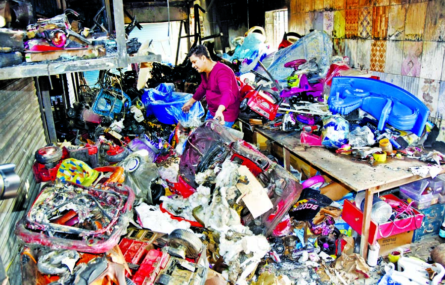 A trader looks at his burned shop at the Rajdhani Super Market in Dhaka on Thursday, a day after the blaze that engulfed the market gutting at least 50 shops.