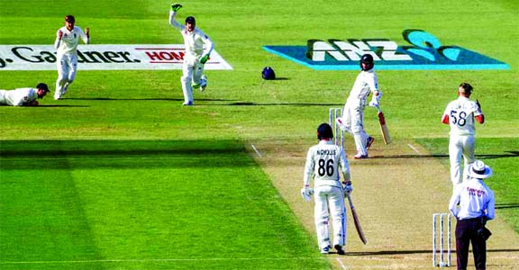 England's Sam Curran (right) celebrates as Ben Stokes takes a catch to dismiss New Zealand's captain Kane Williamson (center) on the second day of the first cricket Test between England and New Zealand at Bay Oval in Mount Maunganui, New Zealand on Frid