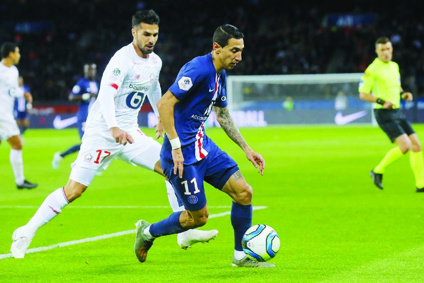 PSG's Angel Di Maria (right) runs with the ball past Lille's Zeki Celik during French League One soccer match between Paris Saint-Germain and Lille at the Parc des Princes stadium in Paris on Friday.