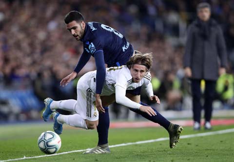 Real Madrid's Luka Modric (left) is fouled by Real Sociedad's Mikel Merino during the Spanish La Liga soccer match between Real Madrid and Real Sociedad at the Bernabeu stadium in Madrid, Spain on Saturday.