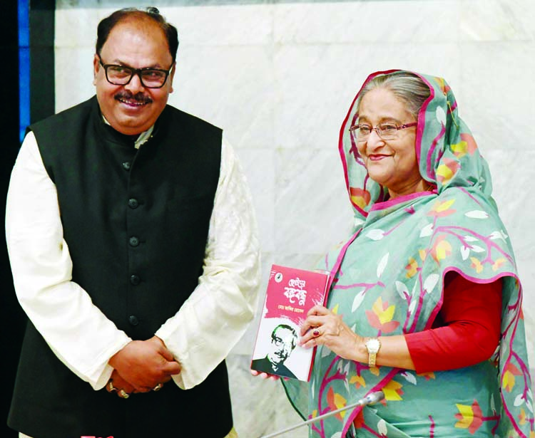 Prime Minister Sheikh Hasina unwrapping the cover of a book titled 'Chhotoder Bangabandhu' written on the works and life of Father of the Nation Bangabandhu Sheikh Mujibur Rahman by State Minister for Primary and Mass Education Zakir Hossain at the Cabi
