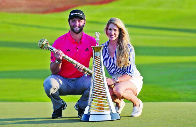 Jon Rahm of Spain poses next to his girlfriend Kelley with the DP World Tour Championship trophies after he won the golf tournament in Dubai, United Arab Emirates onSunday.