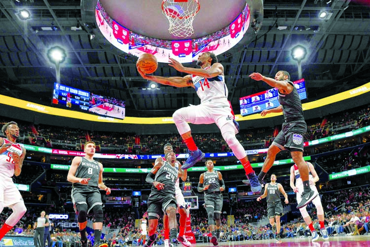 Washington Wizards guard Ish Smith (14) goes to the basket past Sacramento Kings guard Cory Joseph (front right) during the first half of an NBA basketball game in Washington on Sunday.