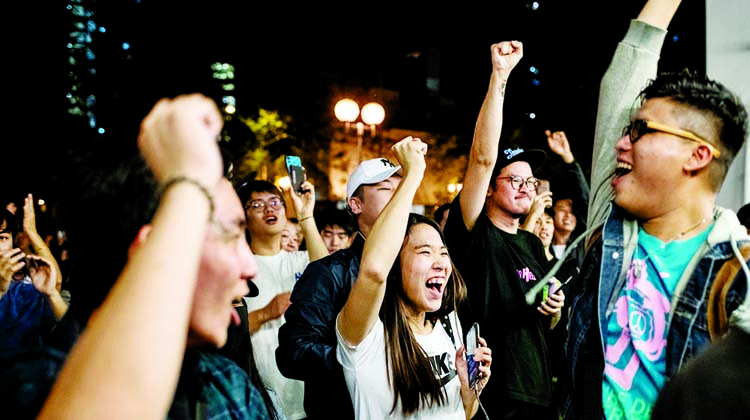 Pro-democracy supporters celebrate victory in HK elections on Monday.