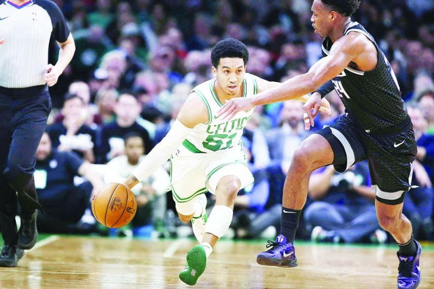 Boston Celtics' Tremont Waters (front left) brings the ball upcourt against Sacramento Kings' Buddy Hield (right) during the second quarter of an NBA basketball game in Boston on Monday.