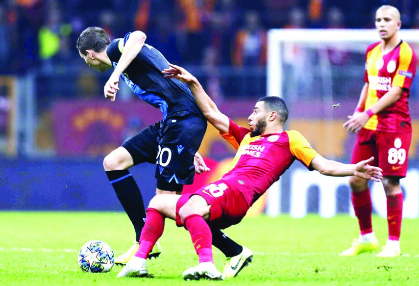 Galatasaray's Younes Belhanda (front) fights for the ball with Brugge's Hans Vanaken during the Champions League group A soccer match between Galatasaray and Club Brugge in Istanbul on Tuesday.