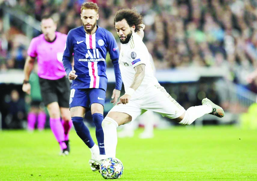Real Madrid's Marcelo (right) fights for the ball against PSG's Neymar during a Champions League Group A soccer match between Real Madrid and Paris Saint Germain at the Santiago Bernabeu stadium in Madrid, Spain on Tuesday.