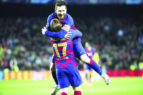 Barcelona's Antoine Griezmann celebrates with teammate Lionel Messi ( top) after scoring his side's third goal during a Champions League Group F soccer match between Barcelona and Dortmund at the Camp Nou stadium in Barcelona, Spain on Wednesday.