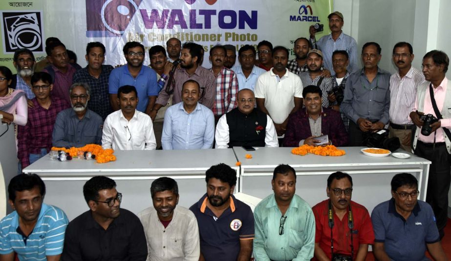 State Minister for Information Dr Murad Hasan with the members of Bangladesh Photo Journalists' Association (BPJA) and the other guests of BPJA pose for a photograph at the BPJA Auditorium on Thursday. They gathered at the Auditorium marking the i