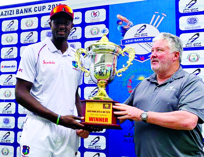 West Indies skipper Jason Holder (left) receives the trophy from Andy Moles, Chief Selector of Afghanistan Cricket Board at the Ekana Stadium on Friday.