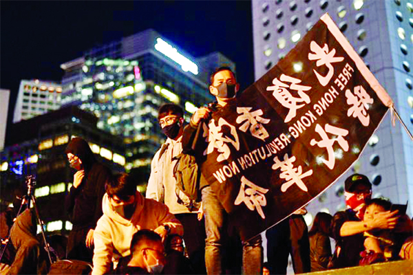 A demonstrator holds a banner that reads 'Free Hong Kong - Revolution Now' as people assemble for a gathering of thanks at Edinburgh Place in Hong Kong's Central district.