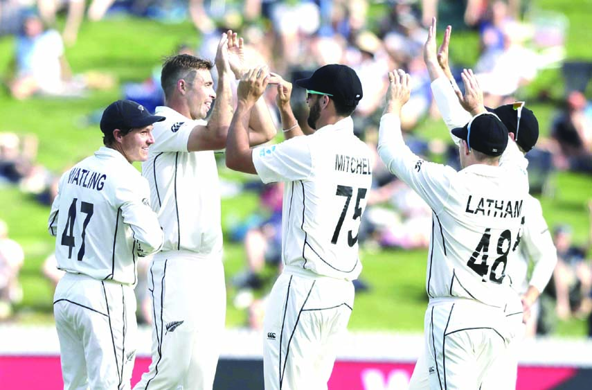 New Zealand's Tim Southee (second left) is congratulated by teammates after taking the wicket of England's Dom Sibley during play on day two of the second cricket Test between England and New Zealand at Seddon Park in Hamilton, New Zealand on Saturday.