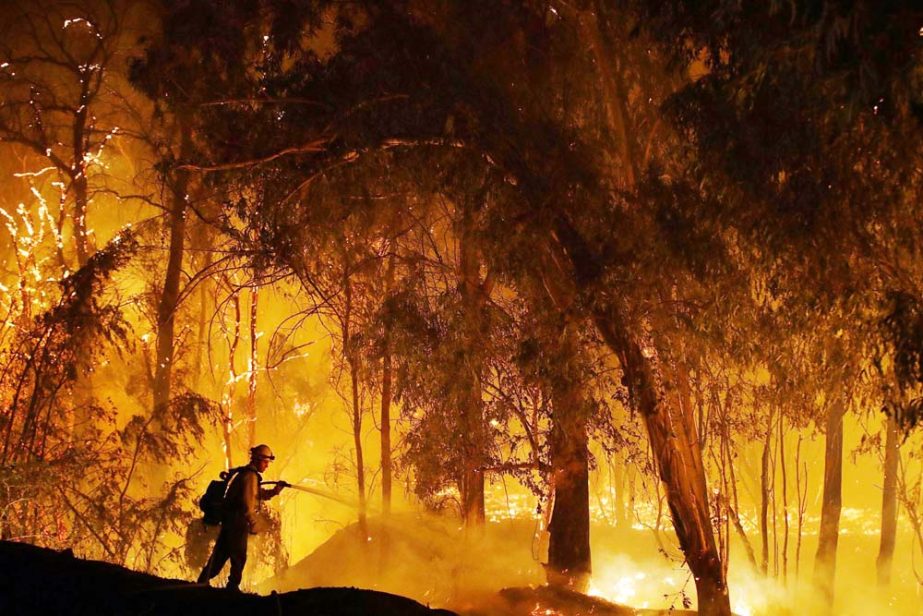 A firefighter battles the Maria Fire in Somis, Calif. Since leaders first started talking about tackling the problem of climate change, the world has spewed more heat-trapping gases, gotten hotter and suffered hundreds of extreme weather disasters. Fires