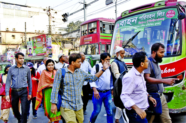 Pedestrians continue to cross roads violating traffic rules despite enrollment of new Road Transport Act. This photo was taken from city's Paltan intersection on Sunday.