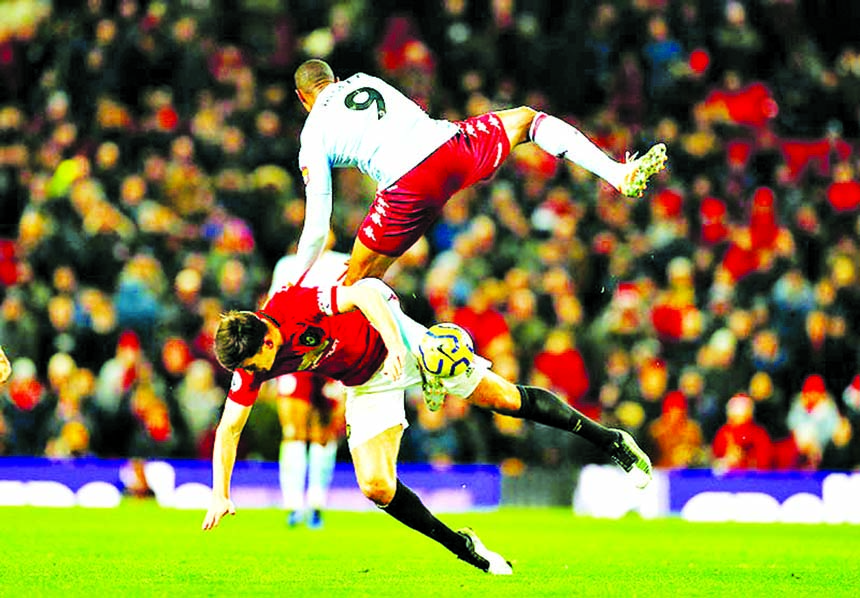 Aston Villa's Wesley (top) in action with Manchester United's Harry Maguire during the Premier League match between Manchester United and Aston Villa, at Old Trafford in Manchester, Britain on Sunday.