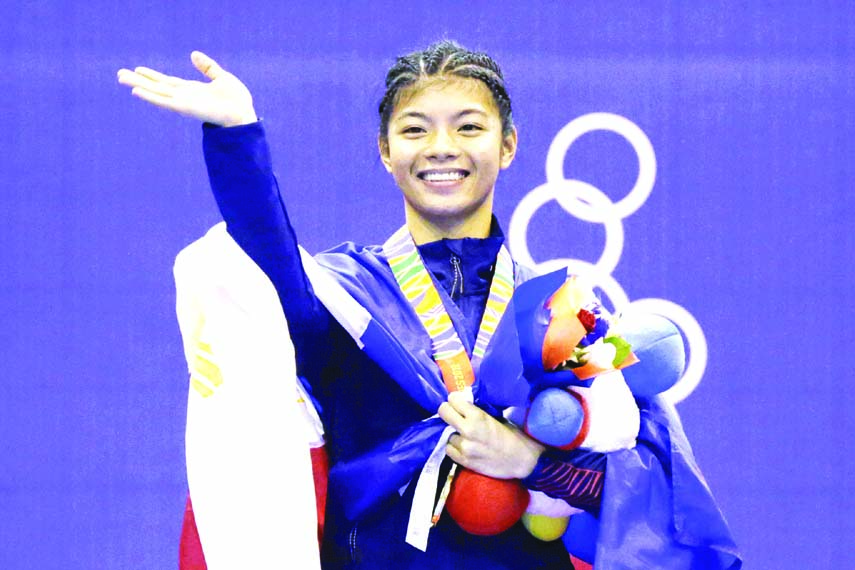 Philippine's Jedah Mae Soriano gestures with medal during victory ceremony for their women's featherweight +50kg-55kg padded stick competition final arnis match at the 30th Southeast Asian Games at the Clark City, Tarlac province, northern Philippines o