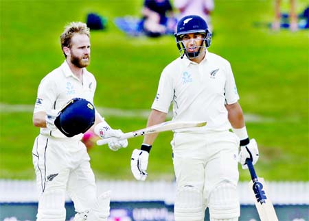 New Zealand's Kane Williamson (left) reacts after scoring a century as teammate Ross Taylor looks on during play on the final day of the second cricket Test between England and New Zealand at Seddon Park in Hamilton, New Zealand on Tuesday.