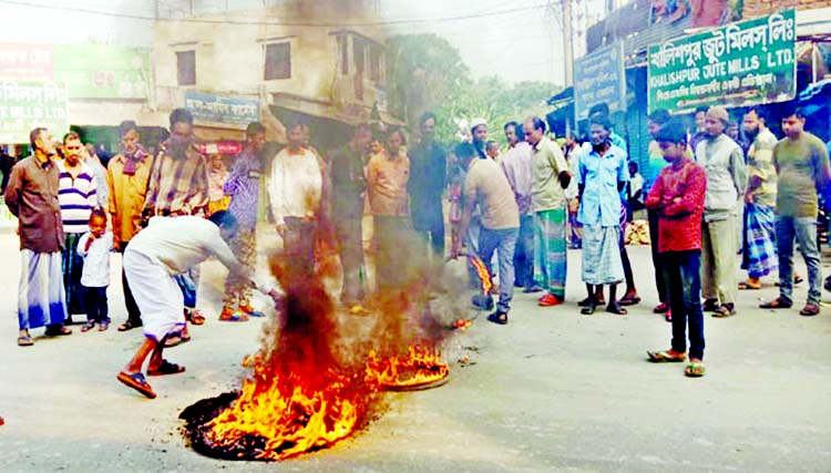 Workers of nine state-owned jute mills enforce a 24-hour strike in front of Daulatpur Jute Mills in Khulna by burning old tyres on Tuesday morning.