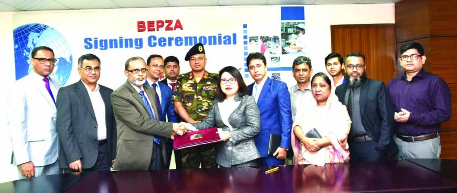 Zillur Rahman, Member (Investment Promotion) of Bangladesh Export Processing Zones Authority (BEPZA) and Ma Miaoyan, Chairman of Ms. Cherry Button Limited, exchanging document after signing an agreement at BEPZA Complex in the city on Thursday to set up