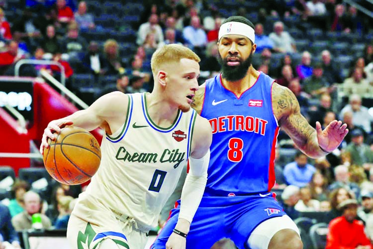 Milwaukee Bucks guard Donte DiVincenzo (0) drives around Detroit Pistons forward Markieff Morris (8) during the first half of an NBA basketball game on Wednesday.