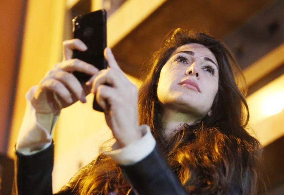 Lebanese anchorwoman Dima Sadek uses her cellphone to film an anti-government protest, in Beirut, Lebanon. Sadek, who last month resigned as an anchorwoman at the LBC TV, blamed Hezbollah supporters for robbing her smartphone while she was filming protest