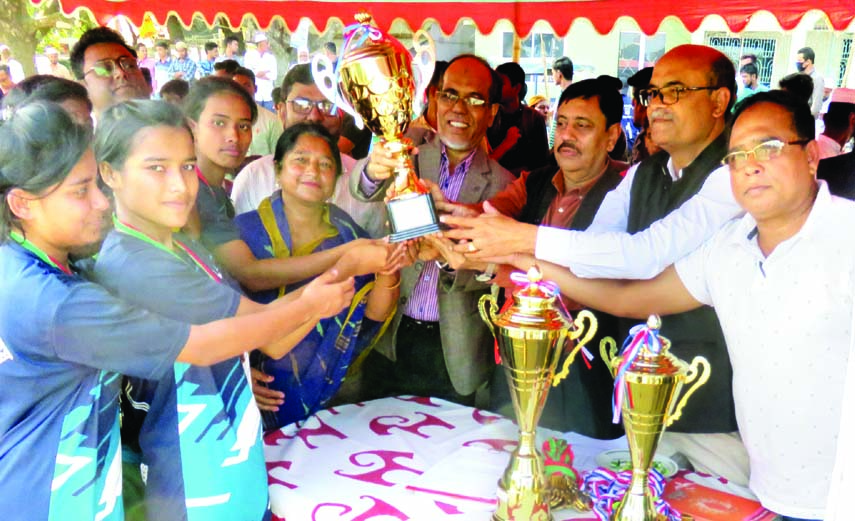 Members of Kishoreganj Poura Mohila College team, the champions in the Zonal Volleyball Competition under Secondary & Higher Secondary Educational Board receiving the trophy from Professor Iman Ali, Principal of Gurudayal Government