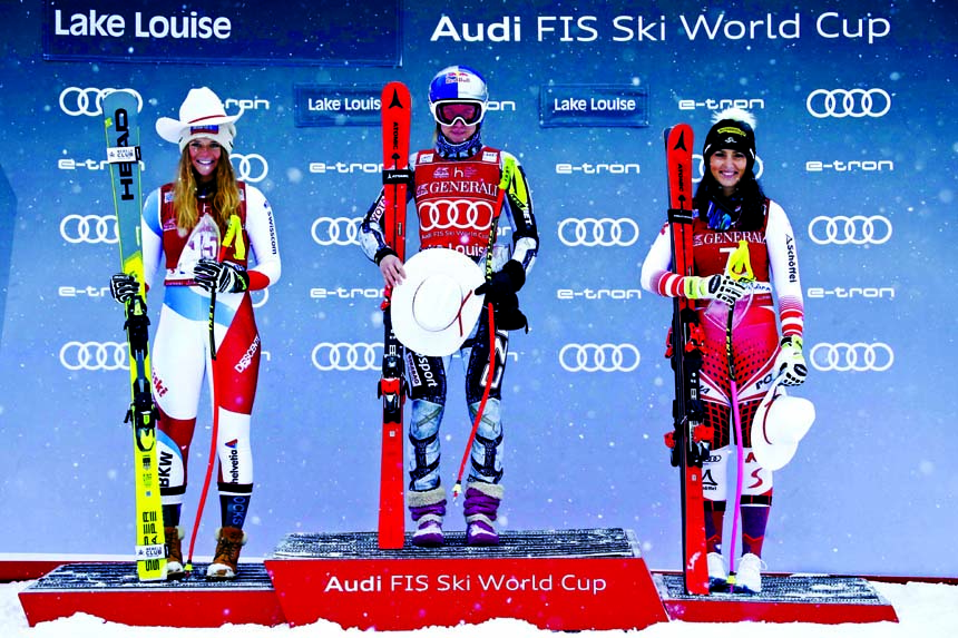 Winner Ester Ledecka (center) of the Czech Republic, celebrates on the podium with second-place finisher Corinne Suter (left) of Switzerland and third-place Stephanie Venier of Austria after the women's World Cup downhill ski race at Lake Louise Alberta