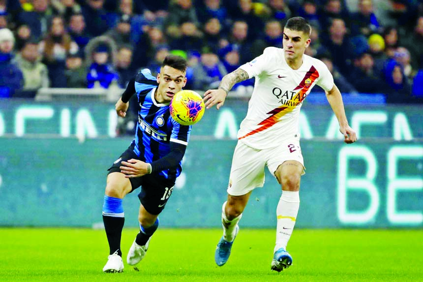 Inter Milan's Lautaro Martinez (left) vies for the ball with Roma's Gianluca Mancini during a Serie A soccer match between Inter Milan and Roma, at the San Siro stadium in Milan, Italy on Friday.