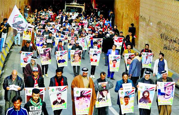 Iraqi demonstrators from Nassiriya city hold the pictures of people who were killed during ongoing anti-government protests in Baghdad, Iraq.
