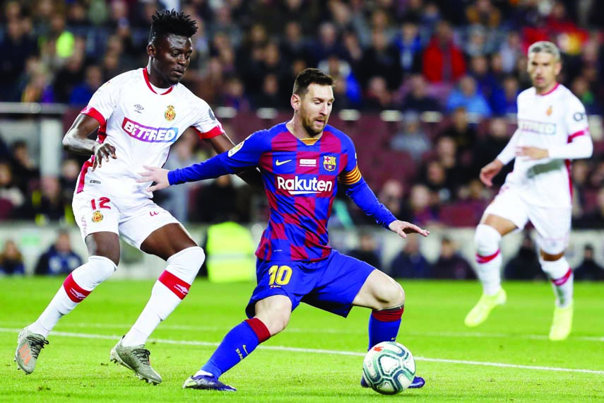 Barcelona's Lionel Messi controls the ball in front of Mallorca's Iddrisu Baba (left) during a Spanish La Liga soccer match between Barcelona and Mallorca at Camp Nou stadium in Barcelona, Spain on Saturday.