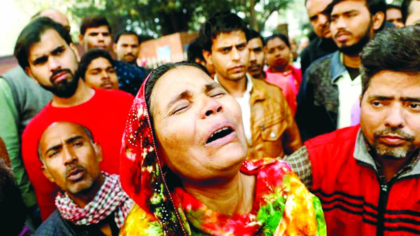 A relative of a victim of the blaze that swept through the factory where labourers were sleeping cries outside a hospital mortuary in New Delhi. Internet photo