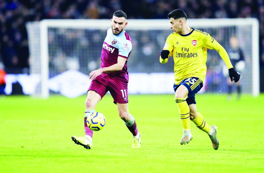 West Ham's Robert Snodgrass (left) and Arsenal's Gabriel Martinelli run for the ball during the English Premier League soccer match between West Ham Utd and Arsenal at the London Stadium in London on Monday.