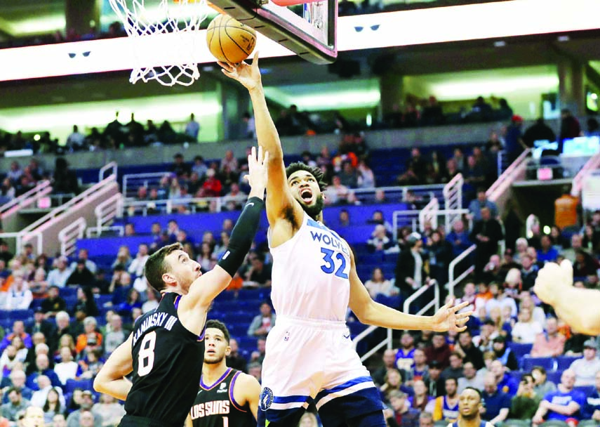 Minnesota Timberwolves center Karl-Anthony Towns (32) shoots over Phoenix Suns forward Frank Kaminsky (8) during the first half of an NBA basketball game in Phoenix on Monday.
