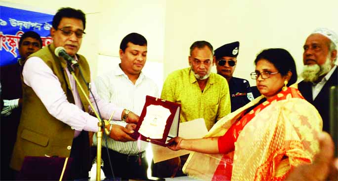 SAGHATA(Gaibandha): Jahangir Kabir, Chairman, Upazila parishad and Mohiuddin Jahangir, UNO, Saghta Upazila giving crest to Kamrunnesa Begum as a best Joyeeta at a function organised by Upazila Administration and Women Affairs Directorate in observan