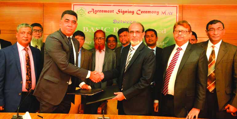 Md. Rafiqul Alam, Managing Director of BASIC Bank Limited and Syed Aminul Kabir, CEO of May International Trade Services Limited, exchanging signing document at the bank's head office in the city on Tuesday. Senior officials from both institutions were p