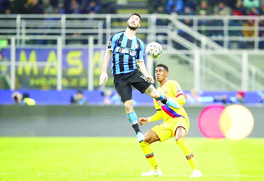 Inter Milan's Matteo Politano (left) duels for the ball with Barcelona's Junior Firpo during the Champions League group F soccer match between Inter Milan and Barcelona at the San Siro stadium in Milan, Italy on Tuesday.