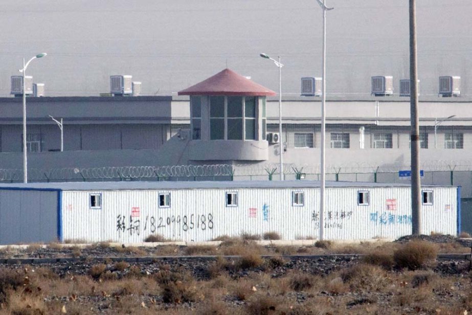 A guard tower and barbed wire fences are seen around a facility in the Kunshan Industrial Park in Artux in western China's Xinjiang region. People in touch with state employees in China say the government in the far west region of Xinjiang is destroying